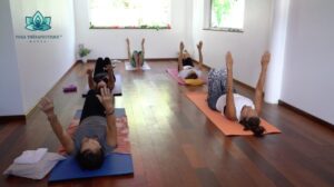 Un professeur de yoga et ses élèves sont couchés sur des tapis