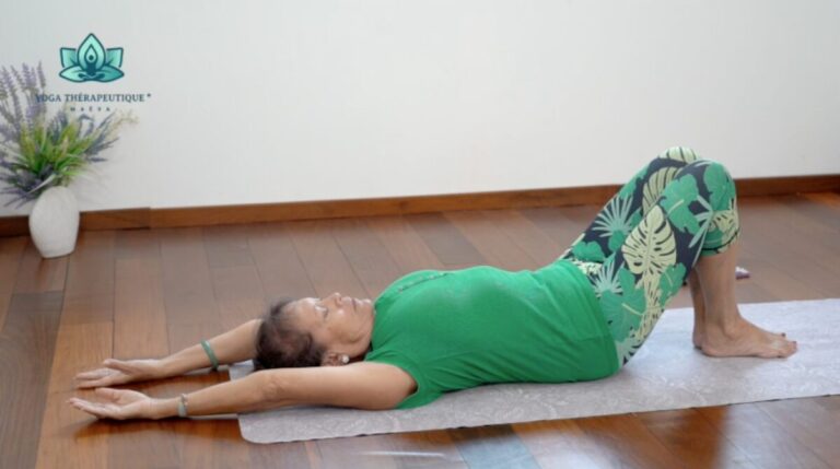 Une femme couchée sur le dos, les jambes pliées, les bras tendus derrière sa tête. Étirement du haut du corps.