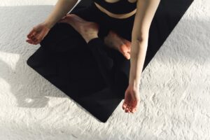 Une femme assise en tailleur vue d'en haut dans une posture de yoga
