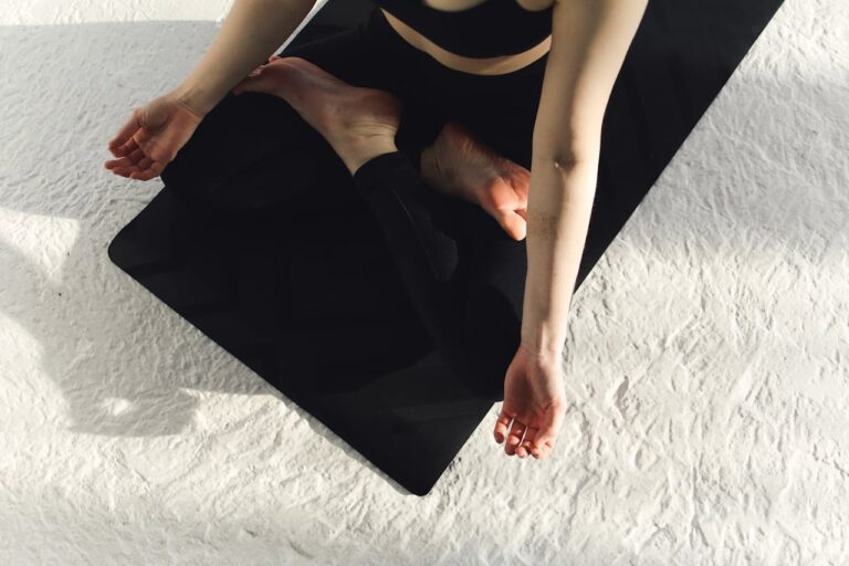 Une femme assise en tailleur vue d'en haut dans une posture de yoga