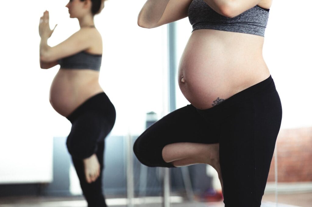 Deux femmes enceintes font la posture de l'arbre